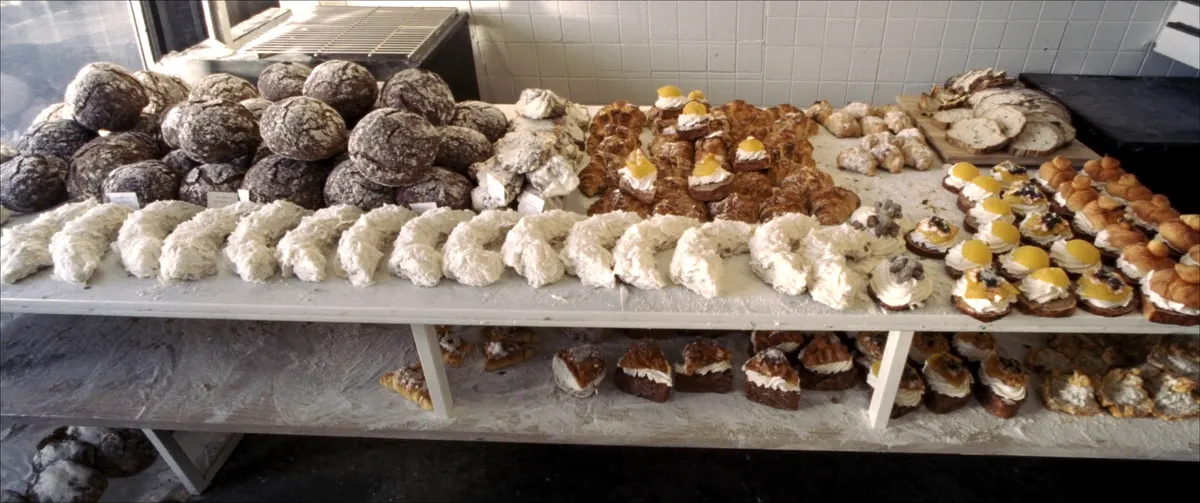 De toog van links naar rechts vol brood, croissants, taartjes en soezen